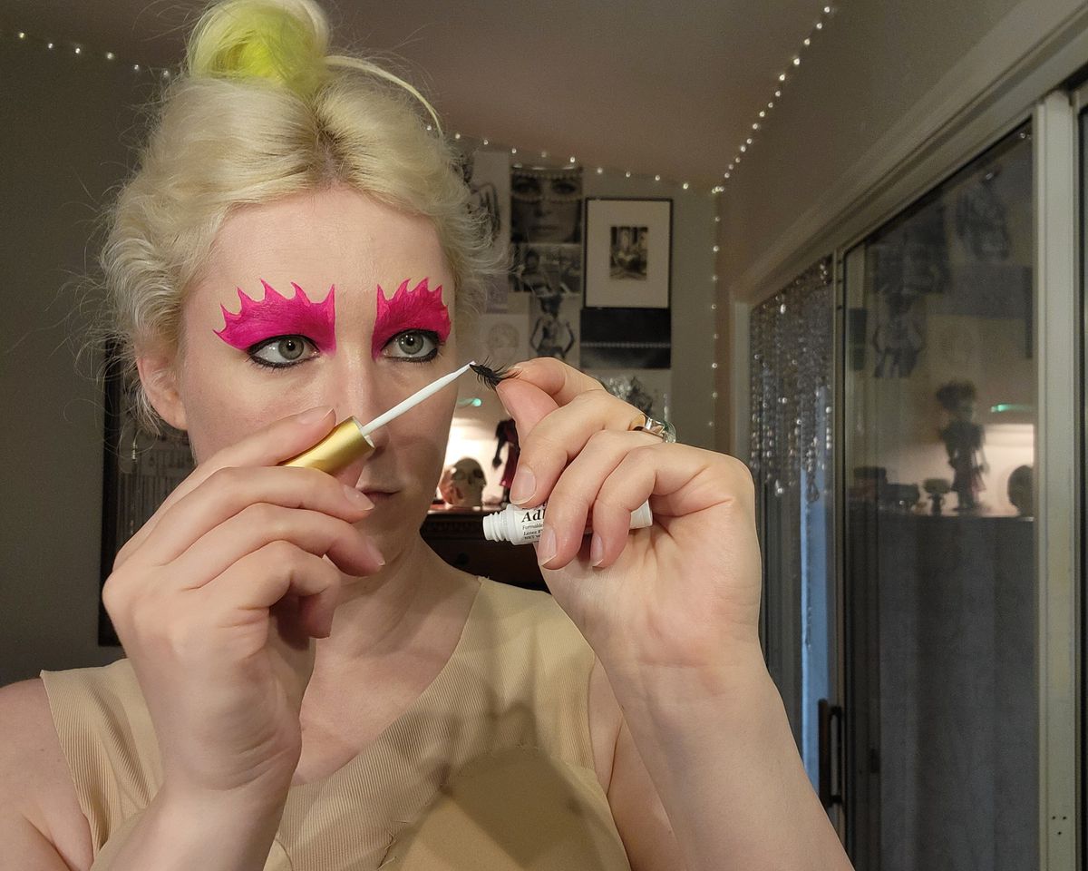 The author painting fake lash adhesive onto a set of false lashes