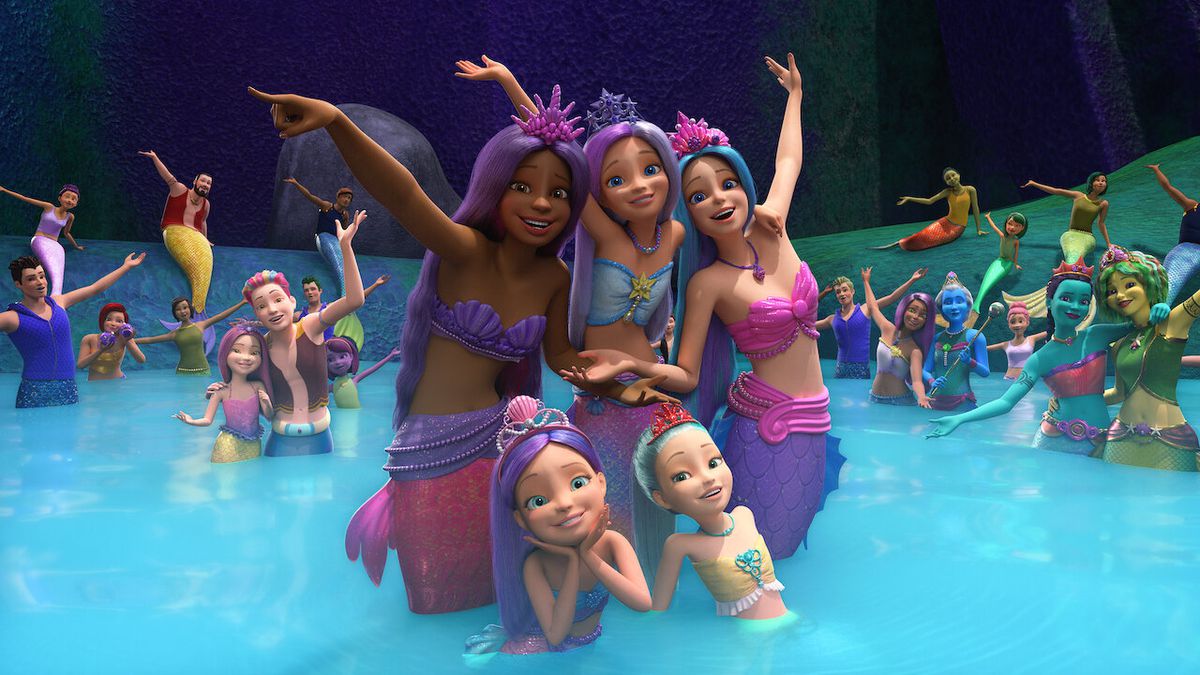 A group of mermaids in bright tail colors all posing together.