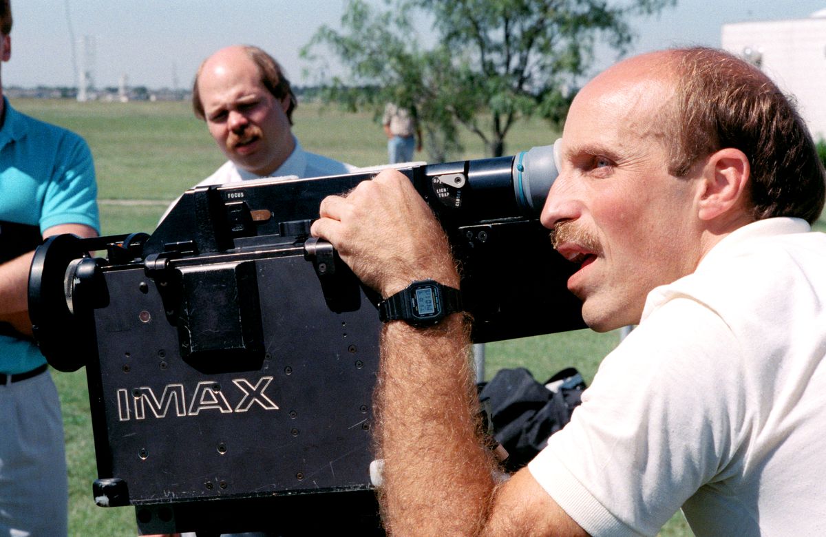 James P. Bagian, STS-29 mission specialist, stands behind an IMAX camera while preparing for a flight on the Space Shuttle Discovery in 1988