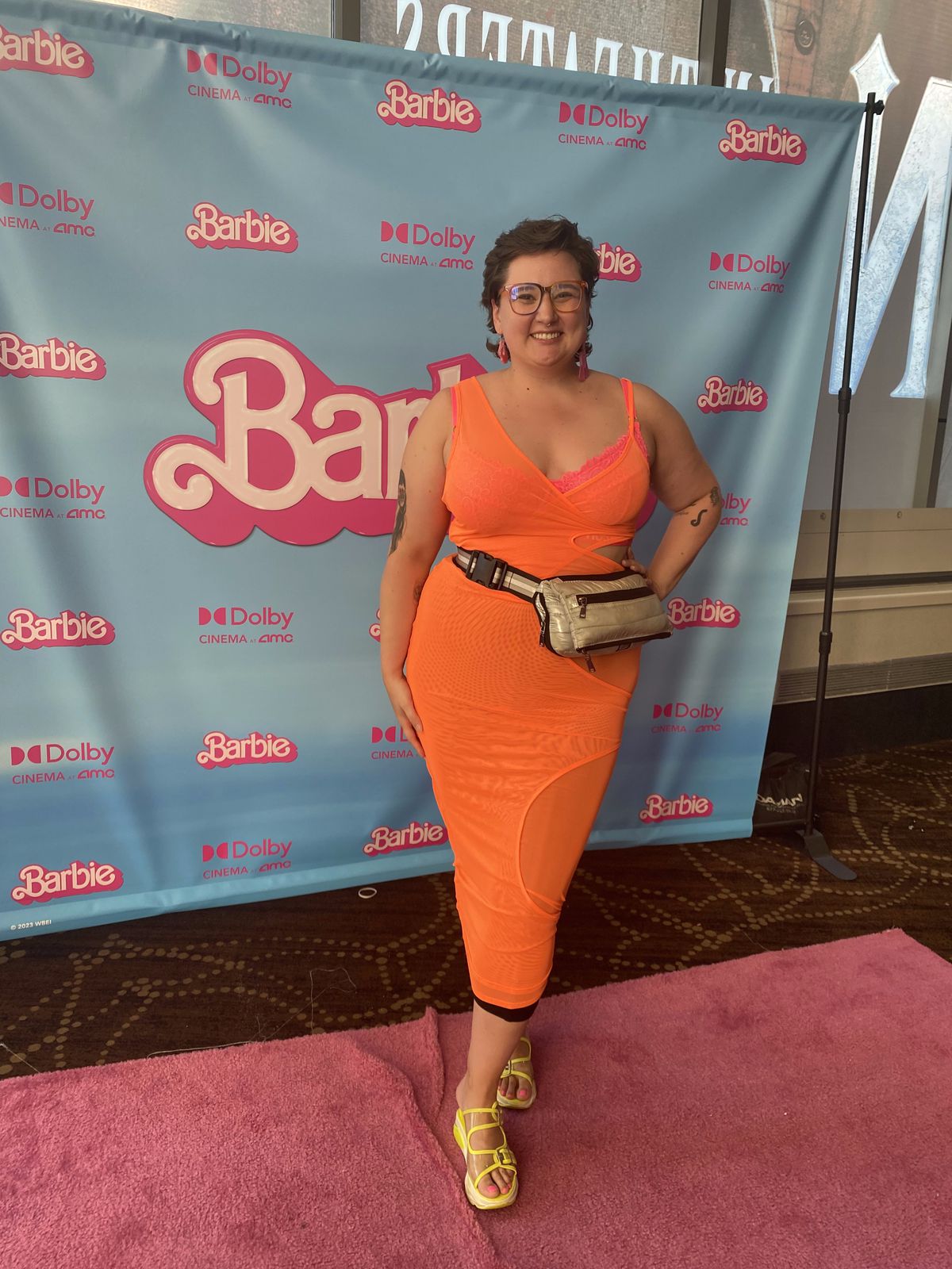 En person i en ljust orange klänning gör sig redo för Barbie