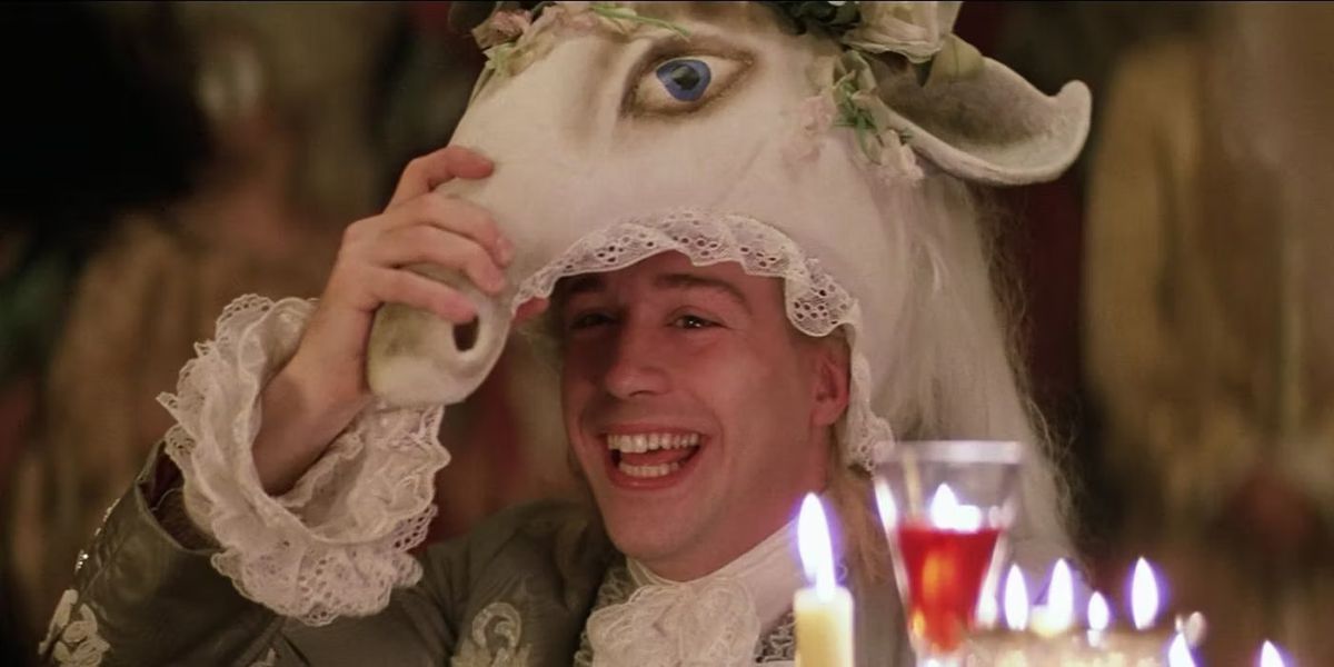 Tom Hulce som Wolfgang Amadeus Mozart ler med en hästmask på huvudet i Amadeus.