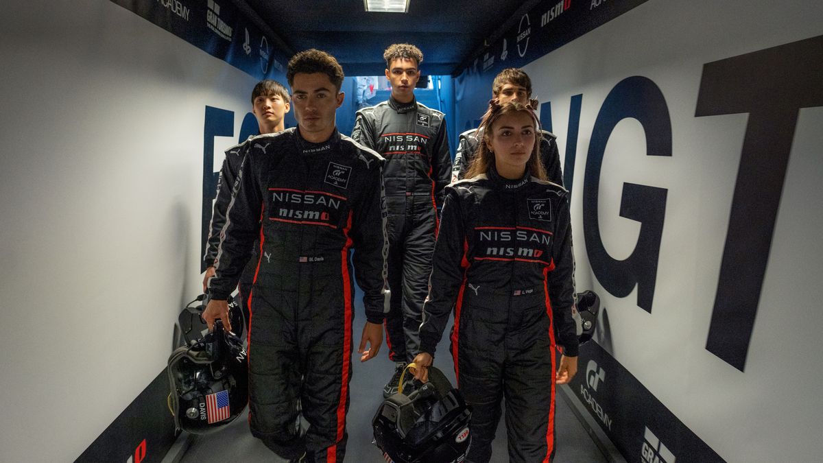 Ett team av unga racerförare iklädda overaller går i en korridor i Gran Turismo-filmen