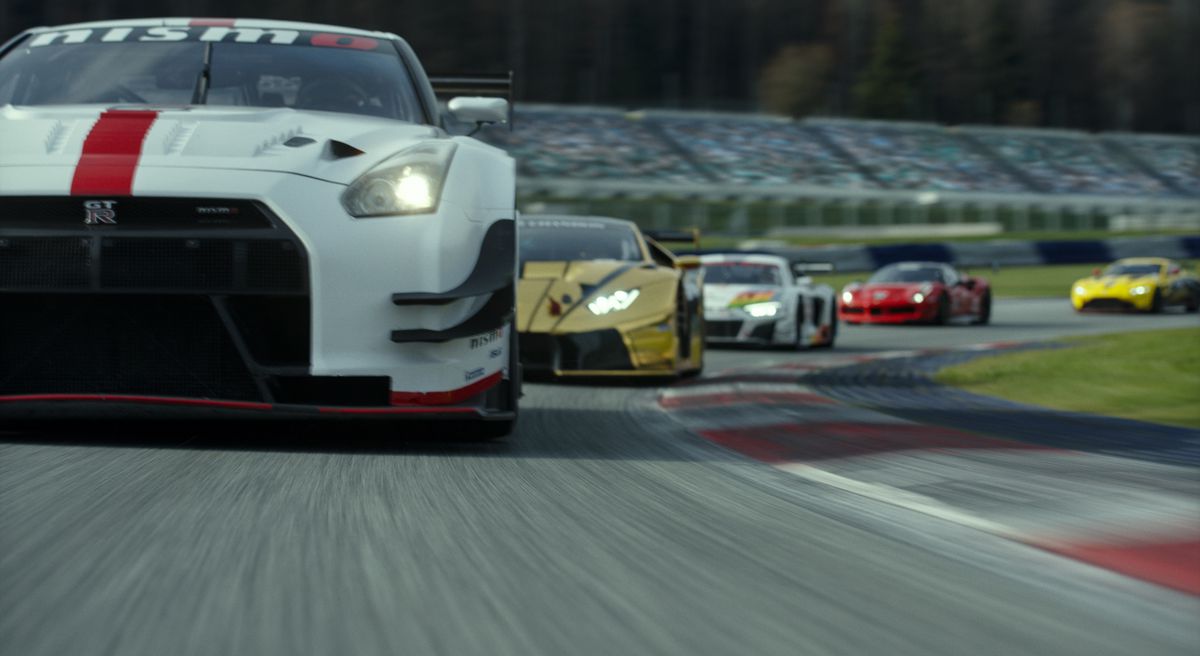 En dynamisk låg bild av en racerbil i fart, ledd av en vit Nissan, i Gran Turismo-filmen