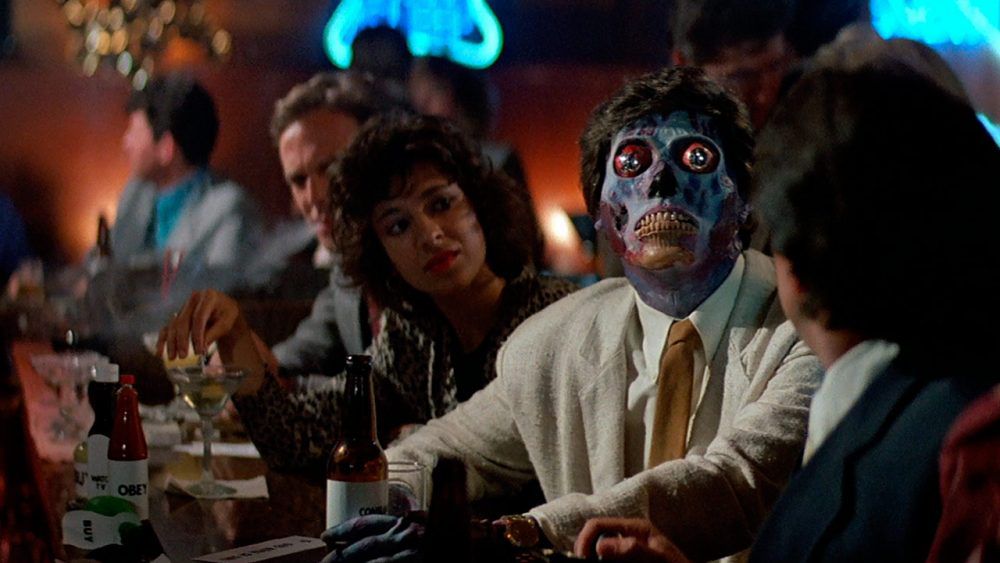 En utomjording som tittar upp på en tv i en bar i They Live (1988)