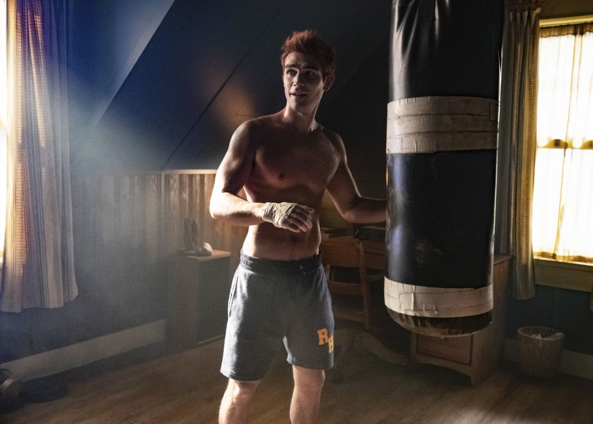 Archie (KJ Apa) standing in his room at his punching bag