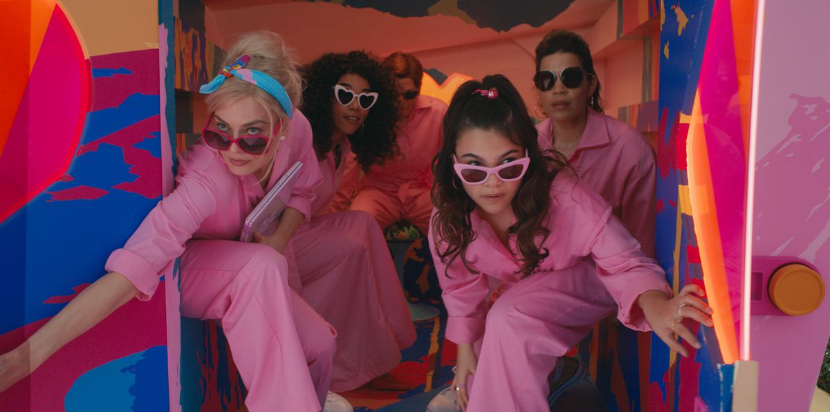 En grupp kvinnor i rosa jumpsuits som tittar ut från baksidan av en skåpbil