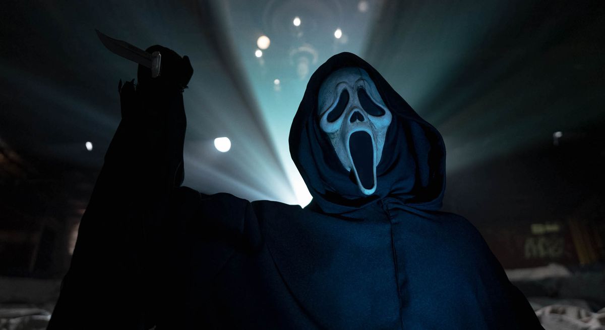 Ghostface, den knivbeväpnade signaturmördaren från Scream-serien, reser sig upp i siluett mot ljuset från en filmprojektor i Scream VI.