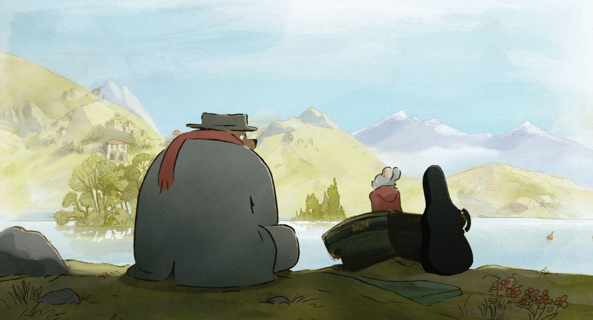 Ernest, en stor björn i formlös grå päls, platt grå hatt och röd halsduk, sitter bredvid Celestine, en liten grå mus i en röd kappa med huva, bredvid en pastoral vattenmassa i Ernest & Celestine: A Trip to Gibberitia
