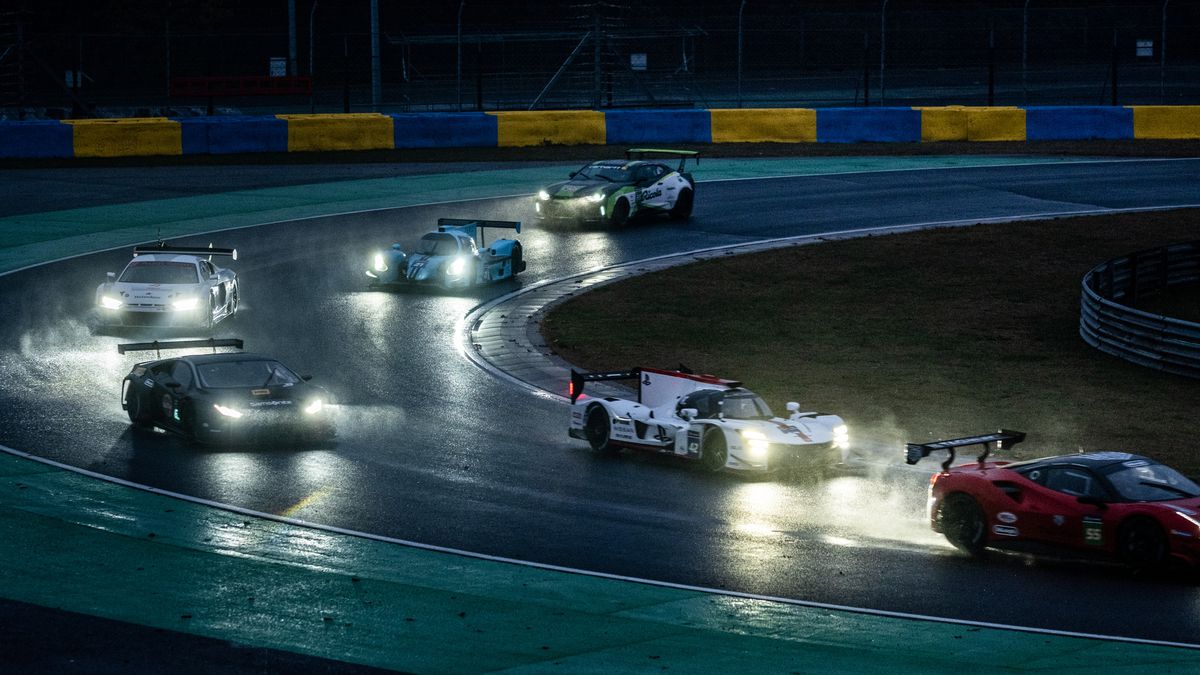 sportbilar med strålkastare på att köra på natten på en raceaway i gran turismo-filmen