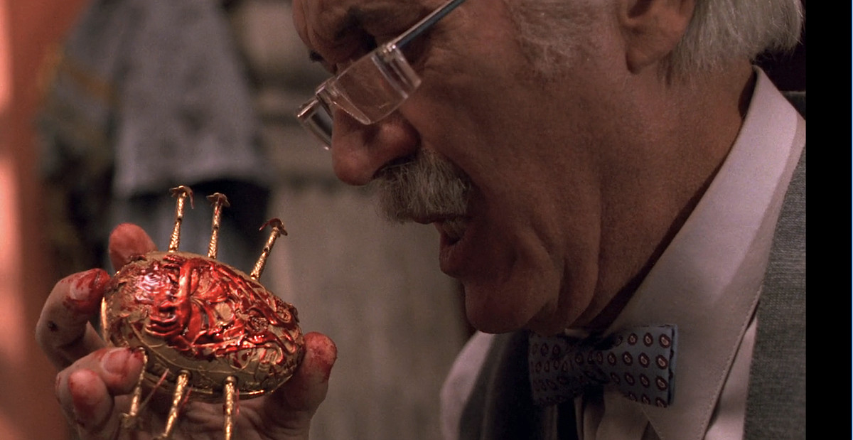 Den äldre antikvitetshandlaren Jesús Gris (Federico Luppi), en vithårig man med båglösa glasögon, rycker till när han håller en gyllene mekanisk skarabé täckt av sitt blod i Guillermo del Toros Cronos