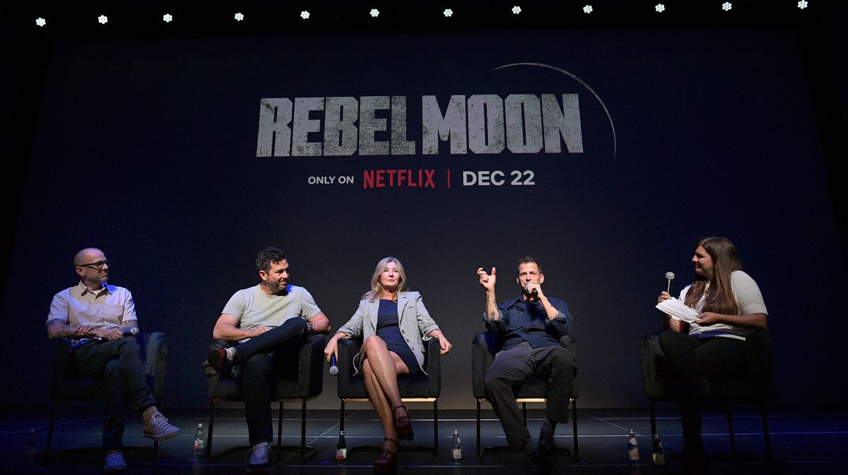 Wesley Coller, Eric Newman, Deborah Snyder, Zack Snyder och Terri Schwartz sitter på rad på en mörk scen med Rebel Moon-titeln bakom sig under Rebel Moon Press Preview den 15 augusti 2023 i Los Angeles, Kalifornien. 