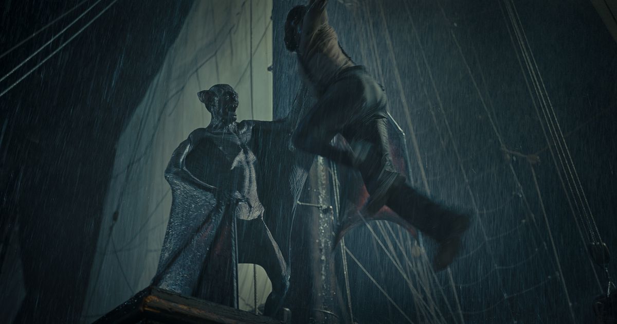 Dracula, som ser ut som en hårlös humanoid fladdermus, står på toppen av ett skepps kråkbo i en mörk regnstorm och hissar upp en stackars man över sig.
