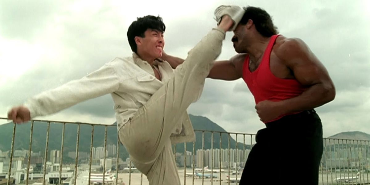 Donnie Yen kicks the top of Michael Woods’s head with the heel of his foot on a rooftop in In the Line of Duty IV.