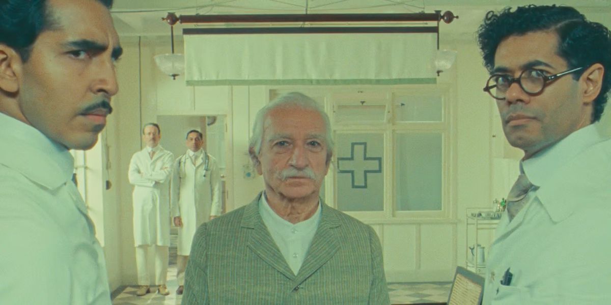 Dev Patel, Ben Kingsley, and Richard Ayoade stand in a medical room wearing white coats in The Wonderful Story of Henry Sugar.