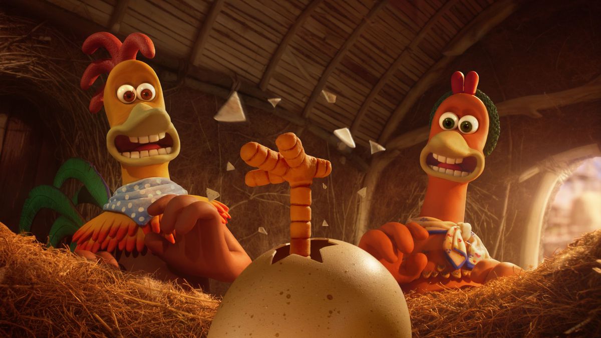 Two chickens in Chicken Run: Dawn of the Nugget look surprised as a little chicken leg pops out of an egg.