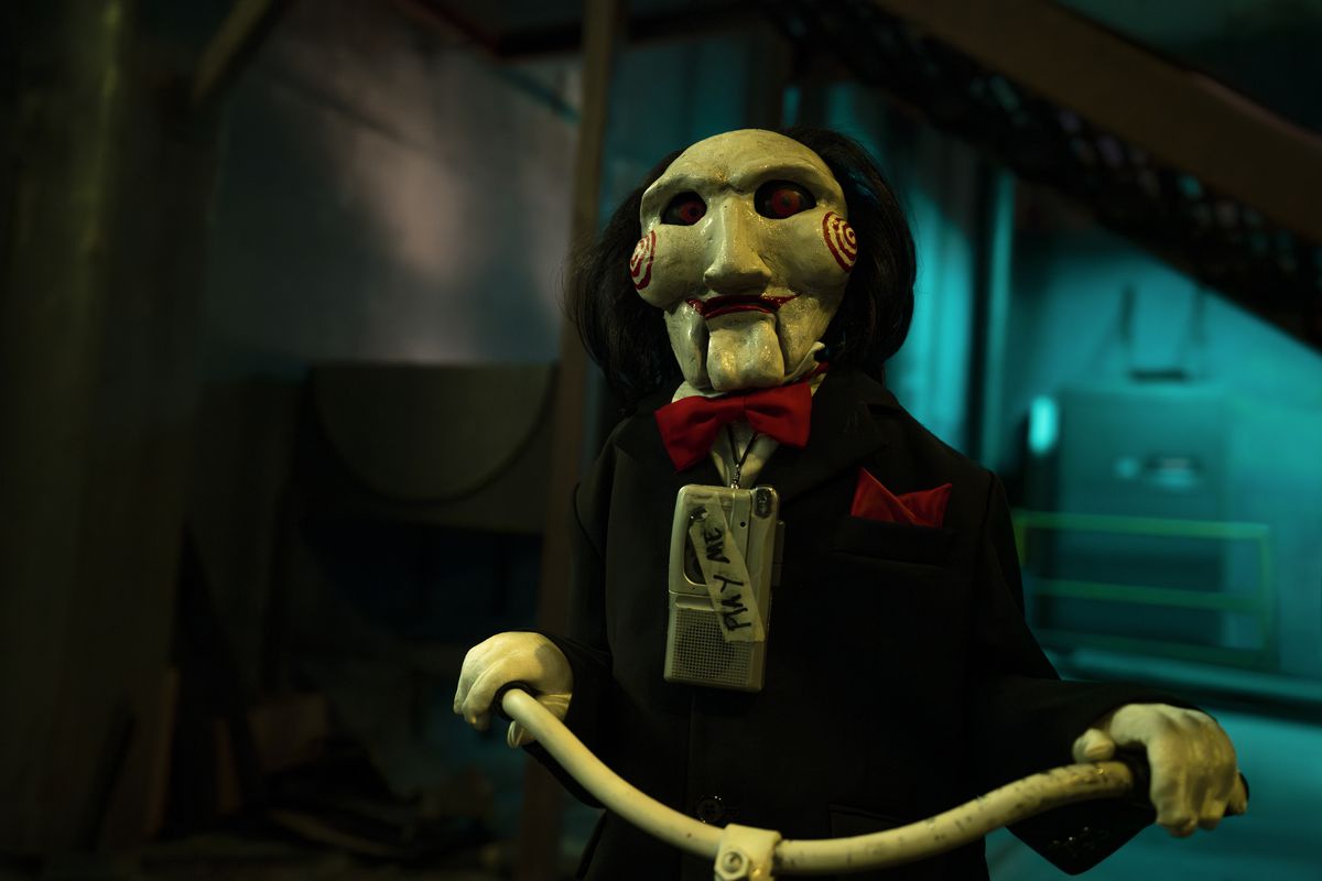 Billy the creepy puppet rides a creepy bicycle creepily in Saw X.