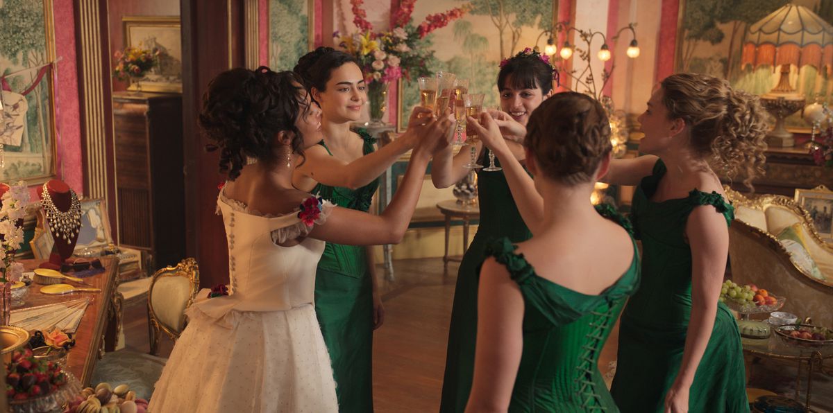 Kristine Frøseth, Alisha Boe, Josie Totah, Aubri Ibrag and Imogen Waterhouse wear fancy dresses and clink dresses in a pink room adorned with flowers in The Buccaneers.