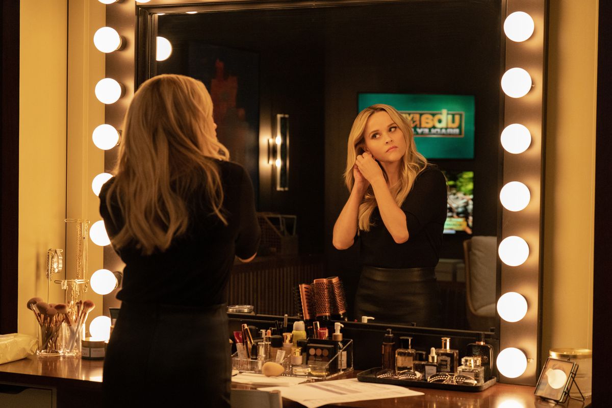 Reese Witherspoon puts earrings on in the makeup room of The Morning Show.