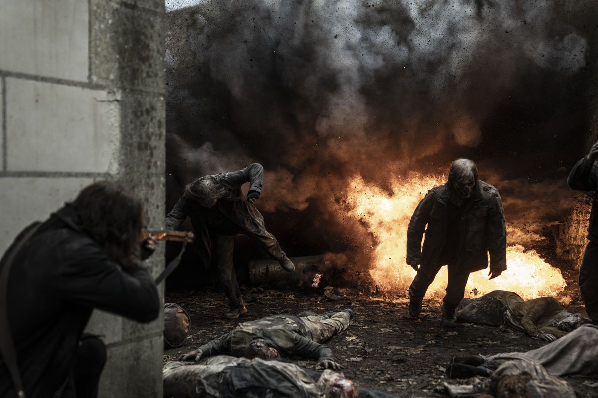 Daryl Dixon (Norman Reedus) riktar ett armborst mot zombies som går ut ur en explosion