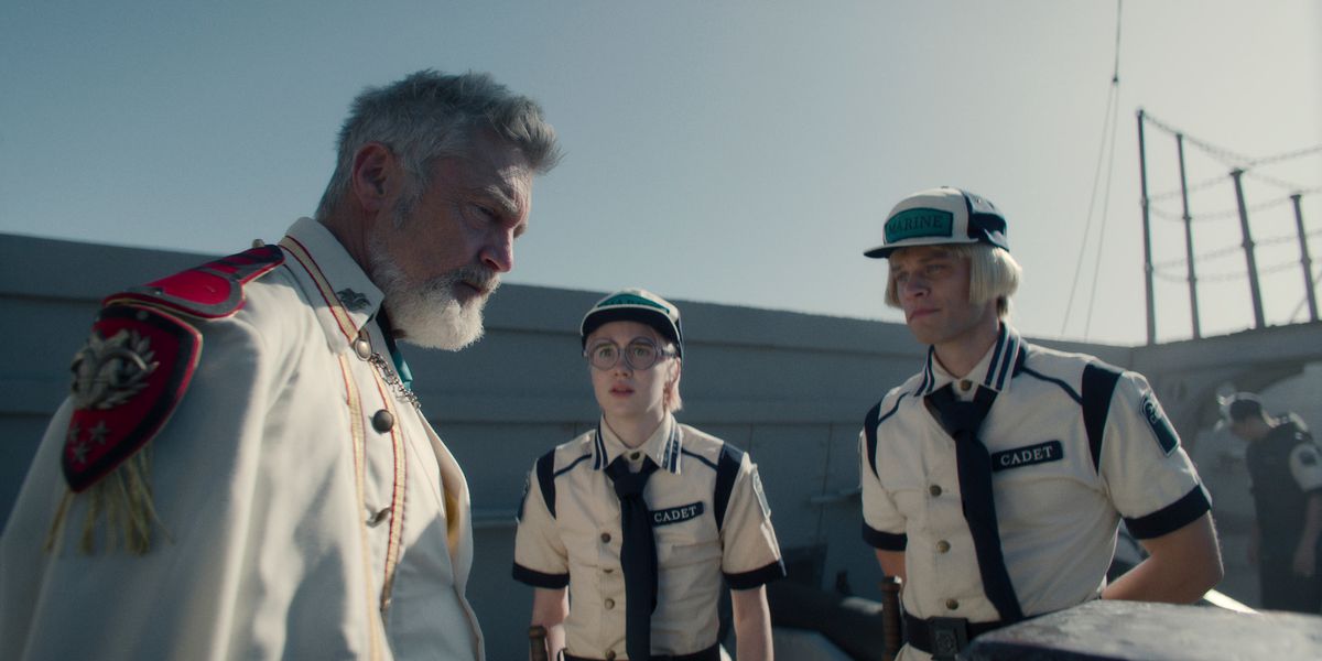 Vincent Regan som viceamiral Garp, Morgan Davies som Koby och Aidan Scott som Helmeppo, som står runt och pratar på däcket på ett marinfartyg