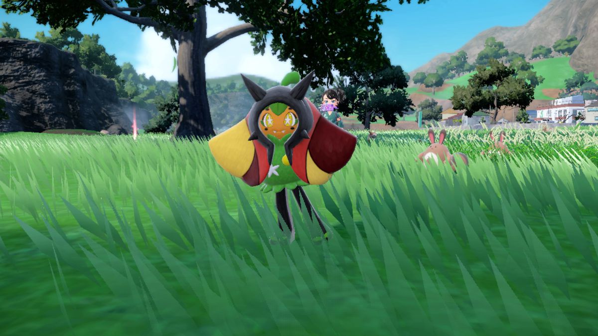En röd Hearthflame Ogerpon i Pokémon Scarlet och Violet i ett gräsbevuxet fält