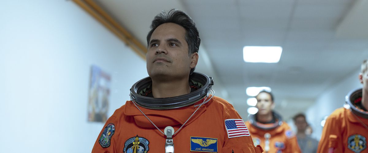 Michael Peña som José M. Hernández går nerför en korridor i en orange rymddräkt i A Million Miles Away.