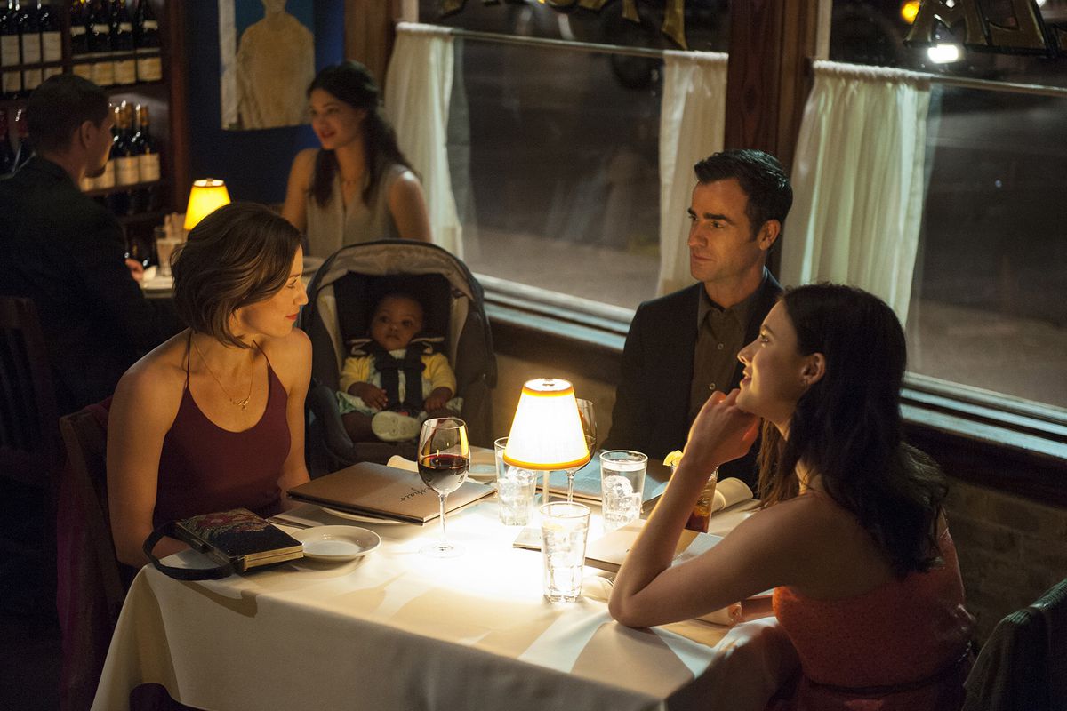 A family gathers around a dinner table at a restaurant in The Leftovers