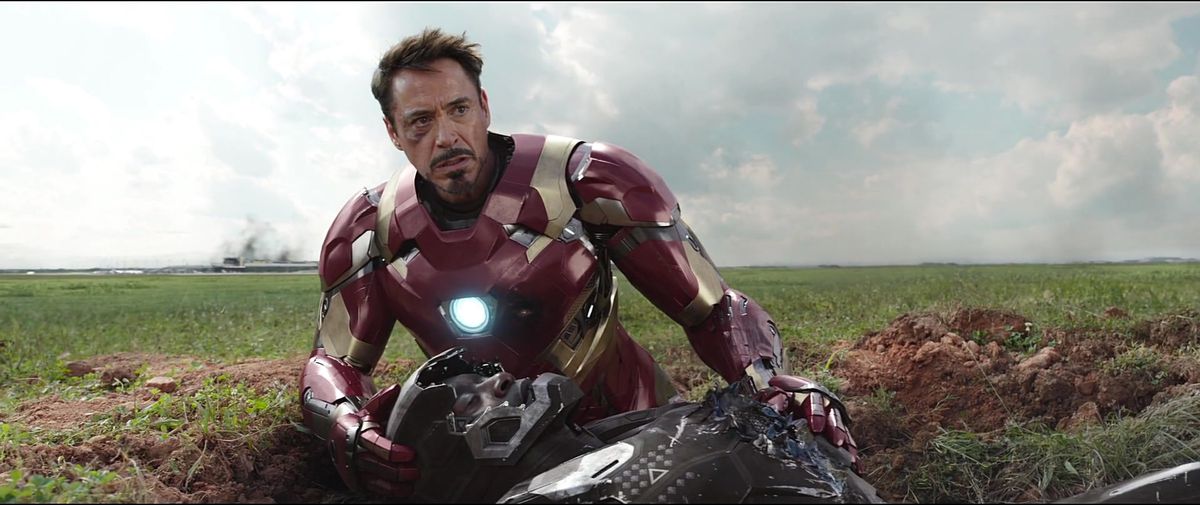 Iron Man holding a dying war machine in CAPTAIN AMERICA: CIVIL WAR