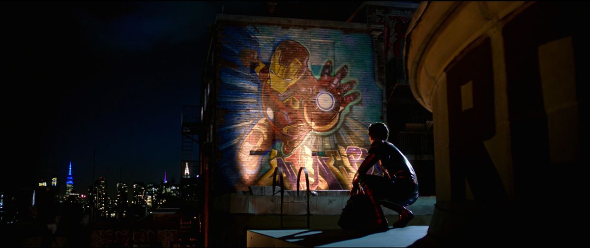 spider-man aka peter parker looks at a mural of iron man in far from home