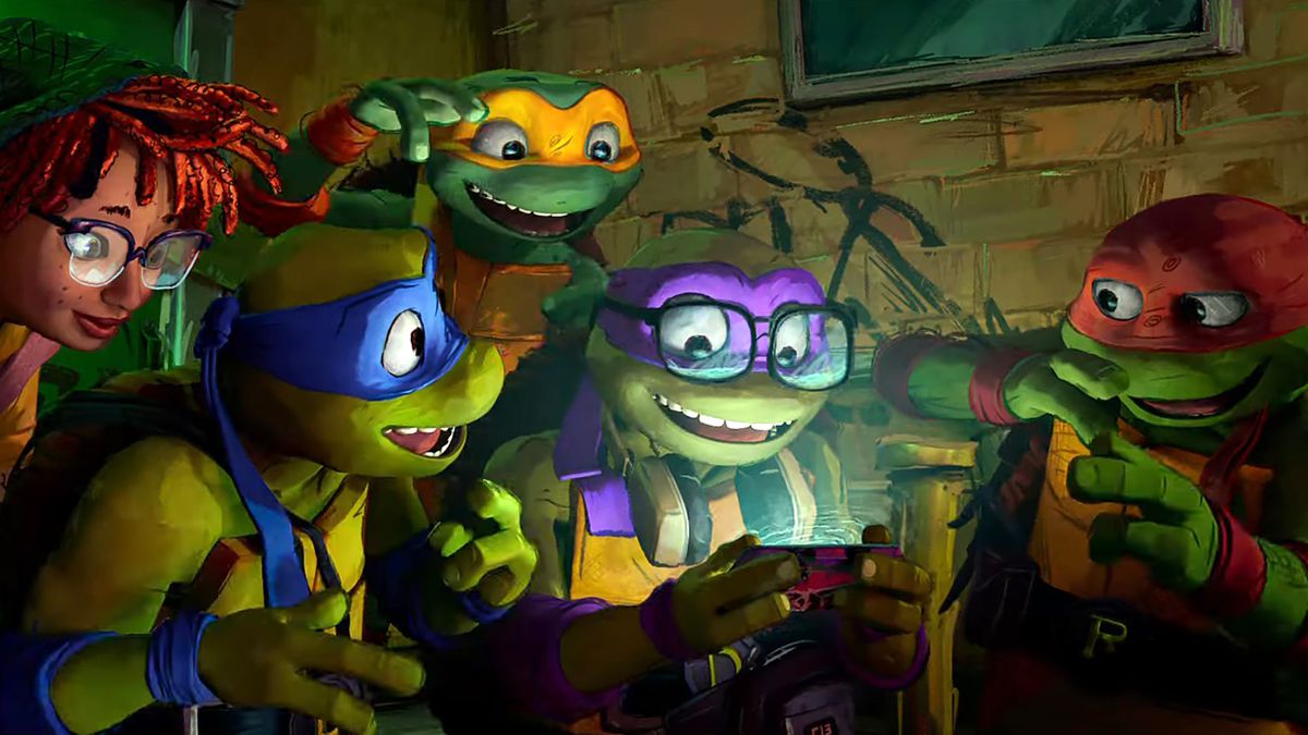 April O'Neil, Leonardo, Donatello, Raphael och Michelangelo skrattar medan de tittar på en mobiltelefon i en stillbild från Teenage Mutant Ninja Turtles: Mutant Mayhem