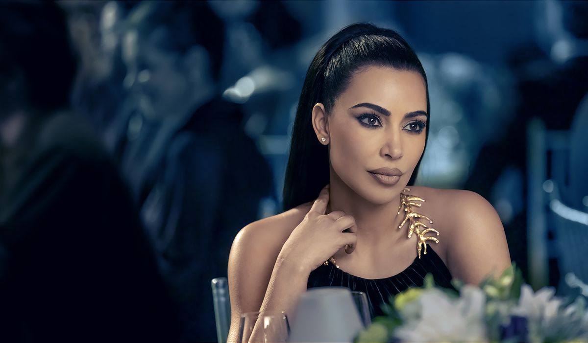 Kim Kardashian sitter vid ett middagsbord