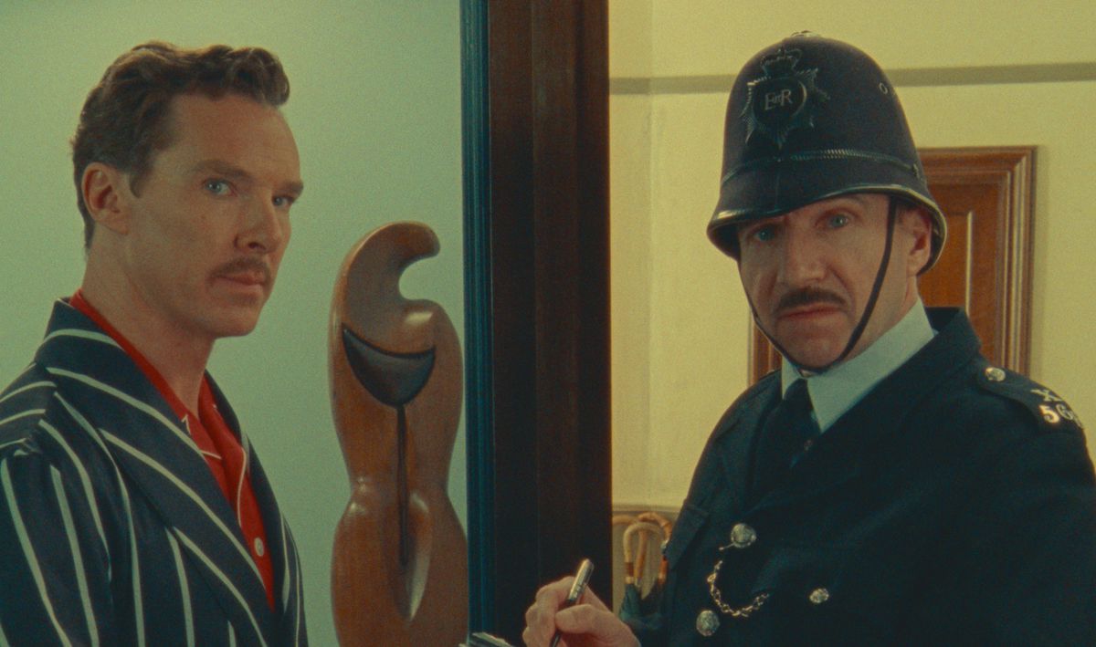 Benedict Cumberbatch (som Henry Sugar) och Ralph Finnes (klädd till polis) tittar direkt in i kameran i en scen från Wes Andersons Netflix-film The Wonderful Story of Henry Sugar