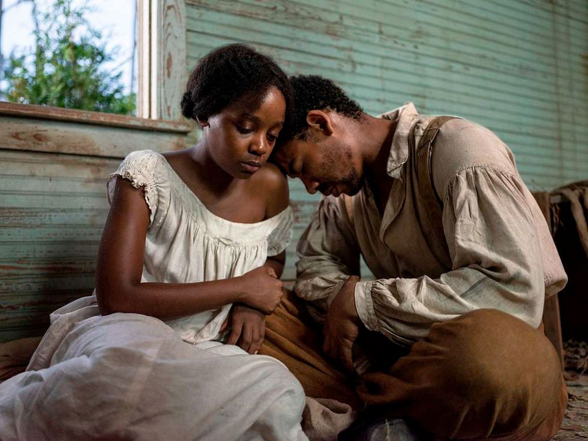 Two Black characters sit by an open window with their heads together in Barry Jenkins’ The Underground Railroad