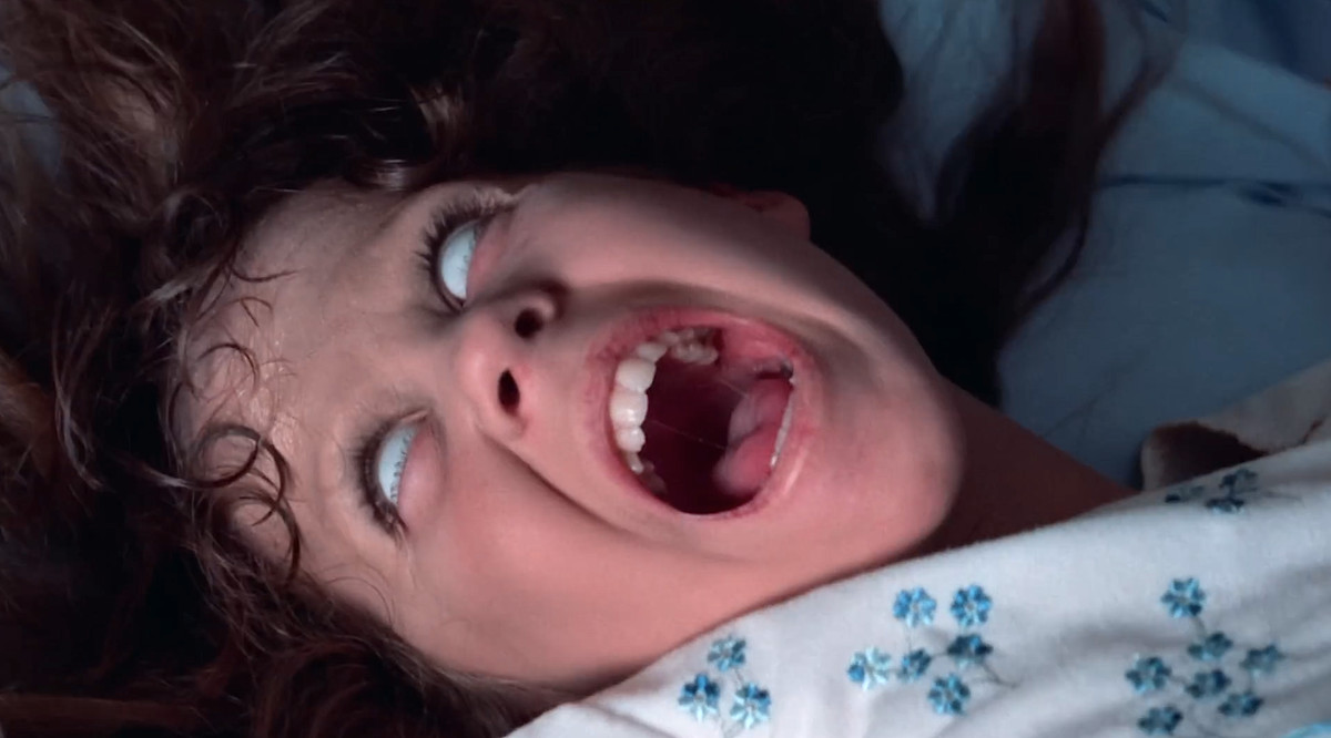 Linda Blair as Regan in The Exorcist, screaming with her hair wild and her eyes completely white