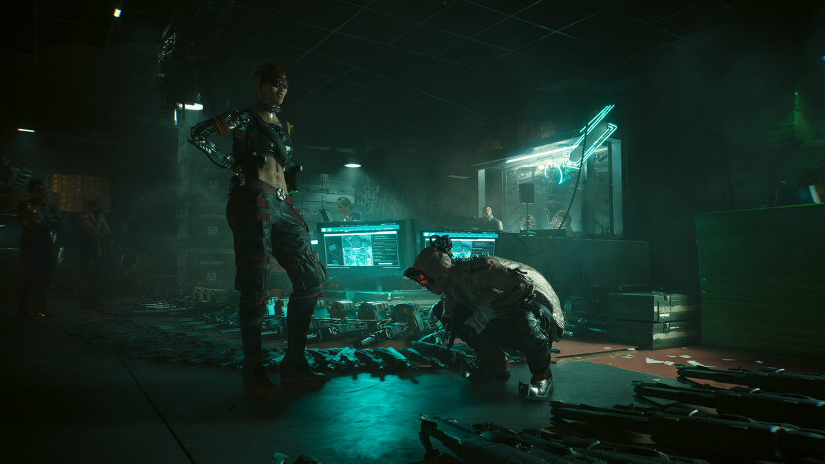 Två cybernetiskt förbättrade karaktärer undersöker en hög med vapen i Dogtown i Cyberpunk 2077
