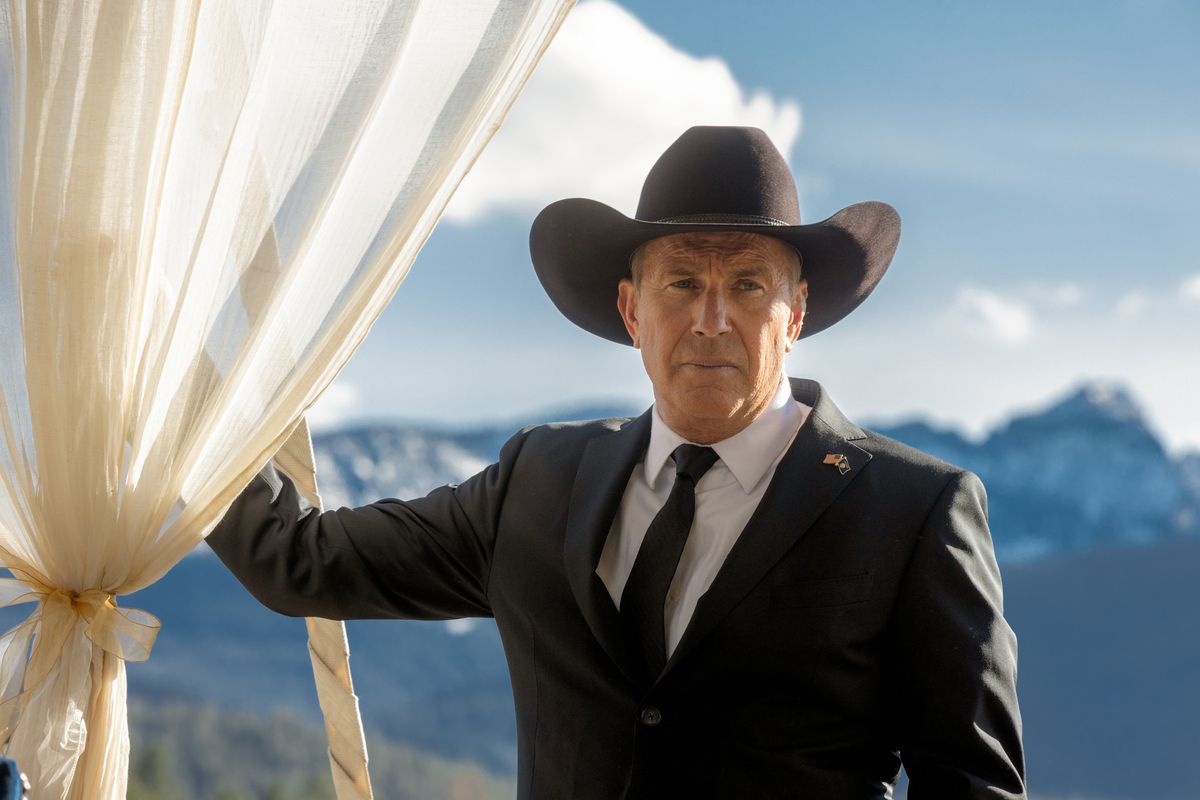 Kevin Costner iklädd svart kostym och svart cowboyhatt och vänd mot kameran på Yellowstone
