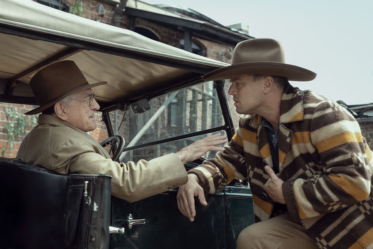 Leonardo DiCaprio, som ser förvirrad ut och iklädd cowboyhatt och grym jacka, pratar med Robert De Niro som sitter i en bil i Killers of the Flower Moon