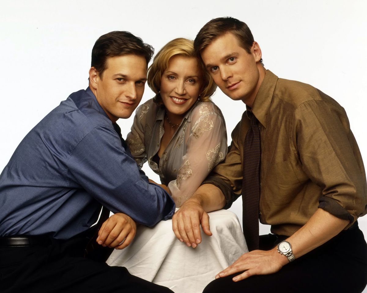 Josh Charles, Felicity Huffman, Peter Krause lean into each other in a promo photo for Sports Night