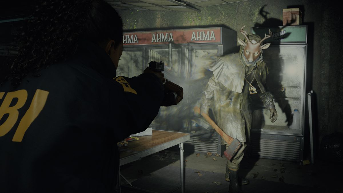FBI-agent Saga Anderson siktar en pistol mot en figur som håller en yxa och bär en rådjursmask i Alan Wake 2