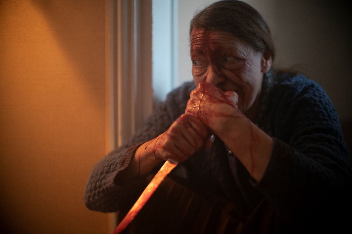 En häxbesatt Madame Daugeron viftar med en kniv och slukar människokött i Marianne (2019).