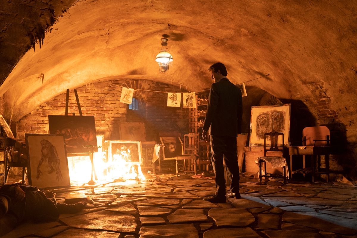 En man (Ben Barnes) står i källaren omgiven av porträtt av fruktansvärda varelser, uppslukade av lågor.