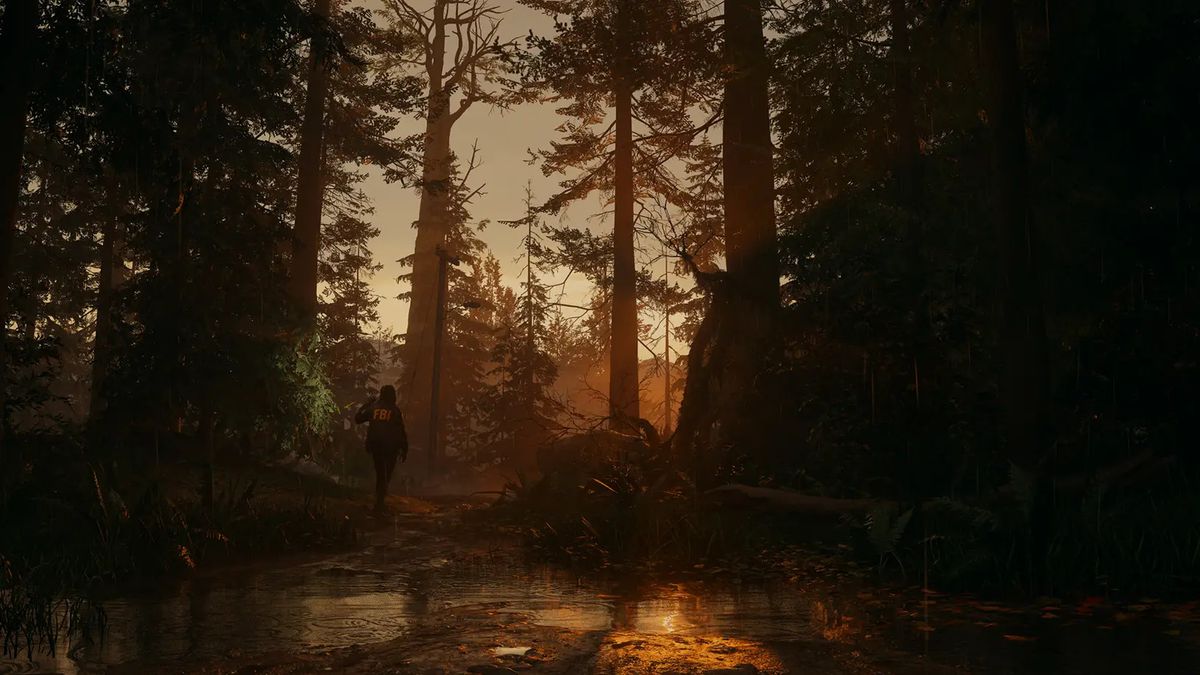 En person som bär en FBI-jacka står bland gigantiska träd nära solnedgången i Alan Wake 2