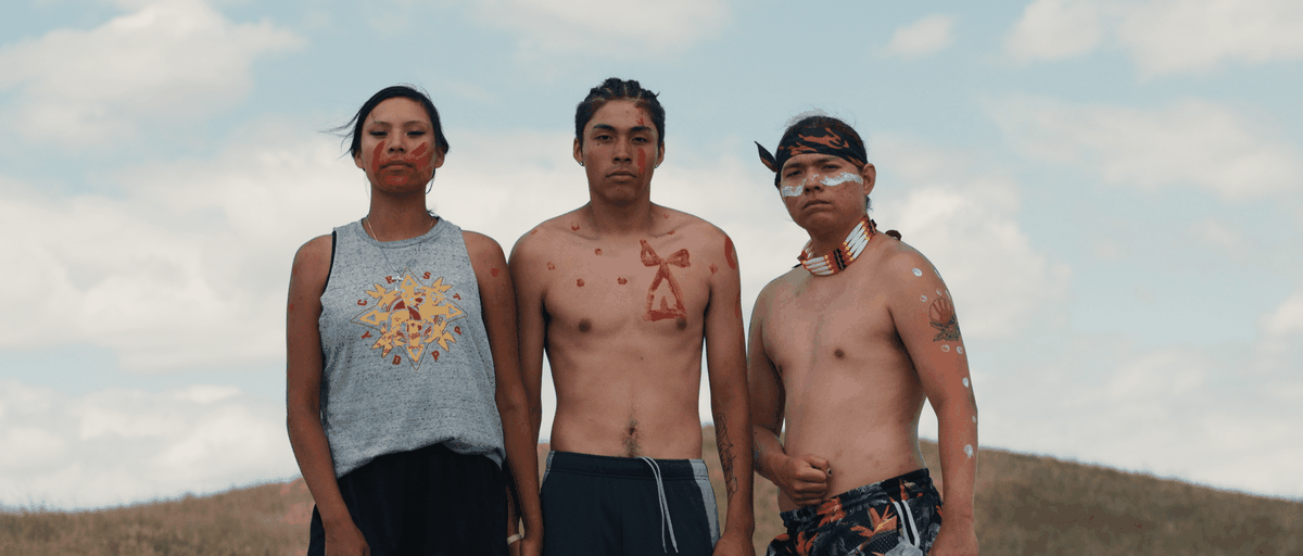 Tre demonstranter som bär ansikts- och kroppsfärg i Lakota Nation vs. USA.