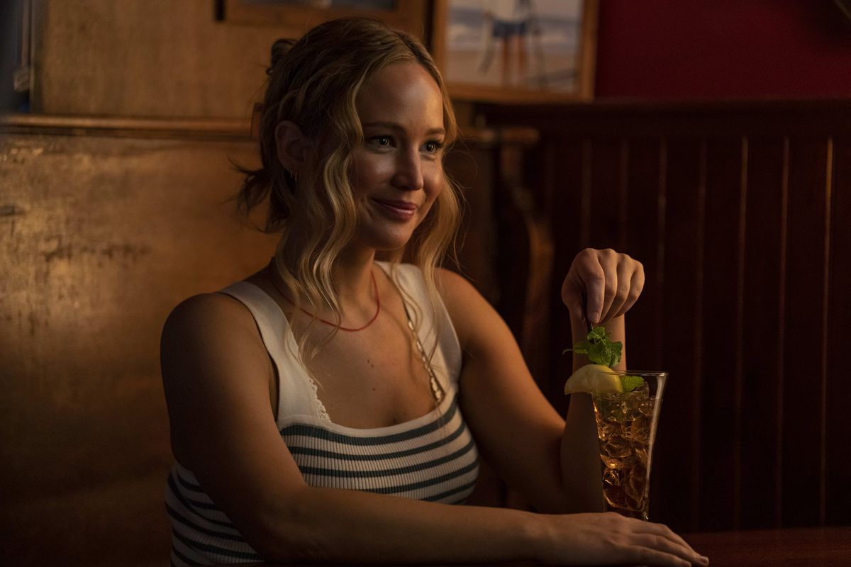 Jennifer Lawrence sits in a tank top at a bar booth with a Long Island Iced Tea in the movie No Hard Feelings.