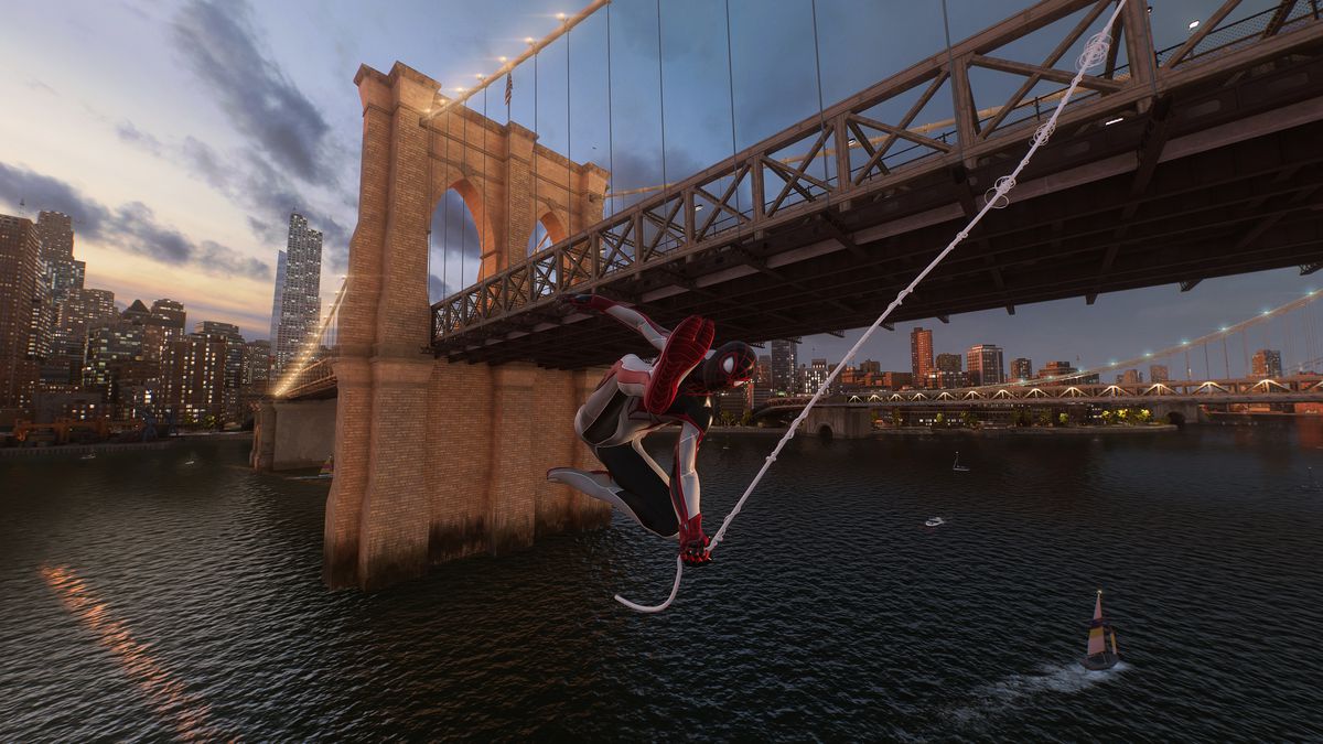Miles Morales svänger under Brooklyn Bridge i skymningen i Marvels Spider-Man 2