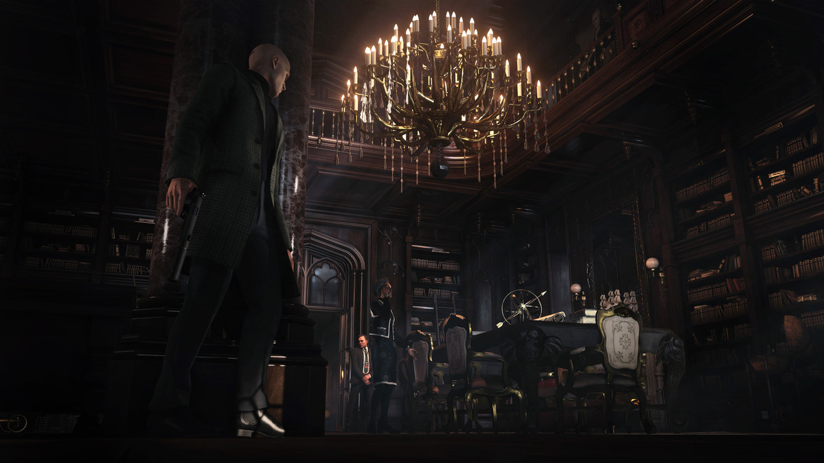 A screenshot from Hitman: World of Assassination showing Agent 47 stalking a target in a dimly lit room