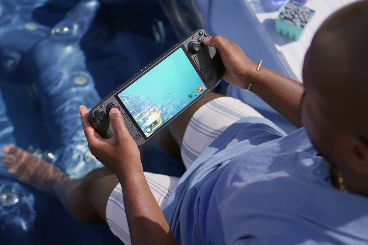 En person som håller i Steam Deck OLED, som spelar Dave the Diver.  Ironiskt nog är personen som håller i konsolen i en pool, tematiskt i linje med det faktum att du är i vattnet i spelet.