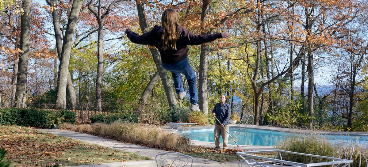 Schlubby professorn Paul Matthews (Nicolas Cage) står vid en pool på bakgården och krattar höstlöv och tittar upp när en tonårstjej i tröja börjar sväva upp i luften framför honom i A24-filmen Dream Scenario