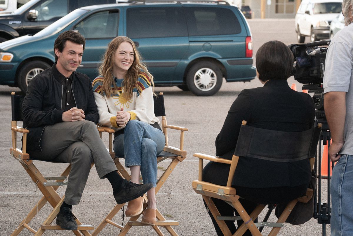Asher (Nathan Fielder) och Whitney (Emma Stone) sitter i stolar och intervjuas av ett nyhetsteam, båda slags falska leende
