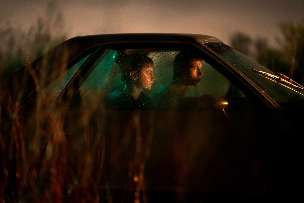 Darby (Emma Corrin) och Bill (Harris Dickinson) sitter i en bil och tittar ut 